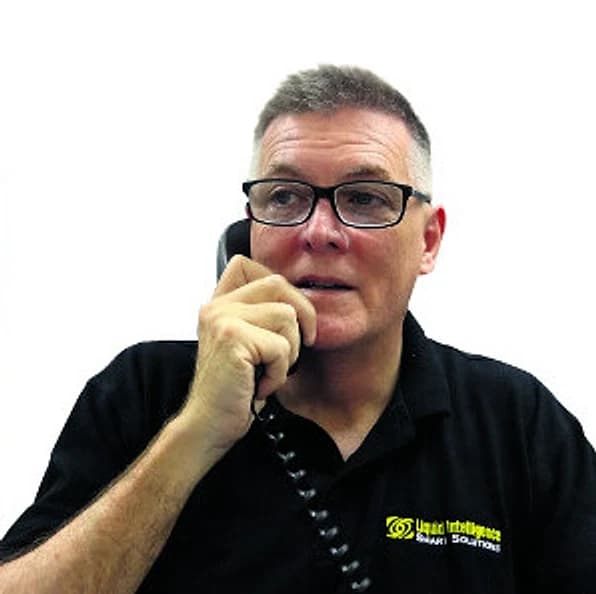 Peter Maher, founder of Liquid Intelligence, on the phone in a Liquid Intelligence shirt