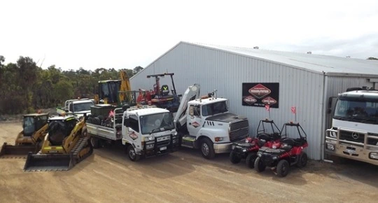 Quad bikes, trucks and earth-moving machinery outside a Western Australian environmental rehabilitation company's shed