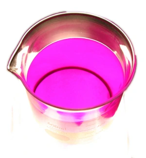 A beaker of Liquid Intelligence 126, lit from below to show its clear purple colour