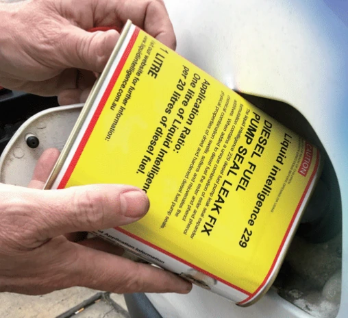 A can of Liquid Intelligence 229 being poured into a vehicle's fuel tank