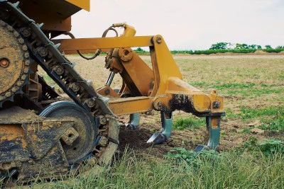 A crawler tractor with a ripper working a paddock