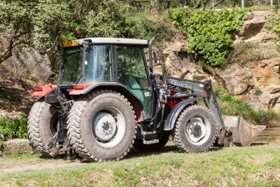 An older tractor working on a rocky property