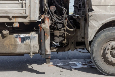 The underside of an old truck with oily running gear