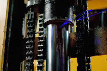 Oil weeping from the top seal of a hydraulic lift cylinder between two lifting chains, with arrows pointing to the leak