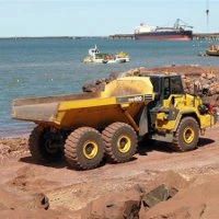 An articulated dump truck on a coastal worksite
