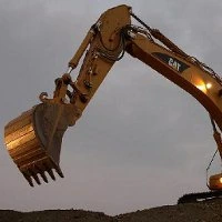 An excavator's boom and bucket raised against the sky
