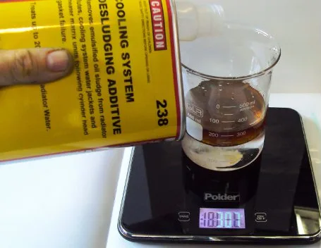 238 being poured from its can into the beaker
