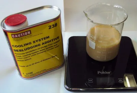 The emulsified mix in the beaker beside a can of 238