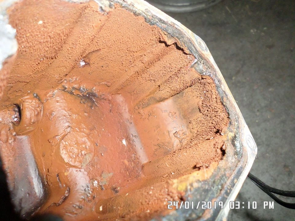Inside the coolant tank, coated in rust, including the rubber seal around its top