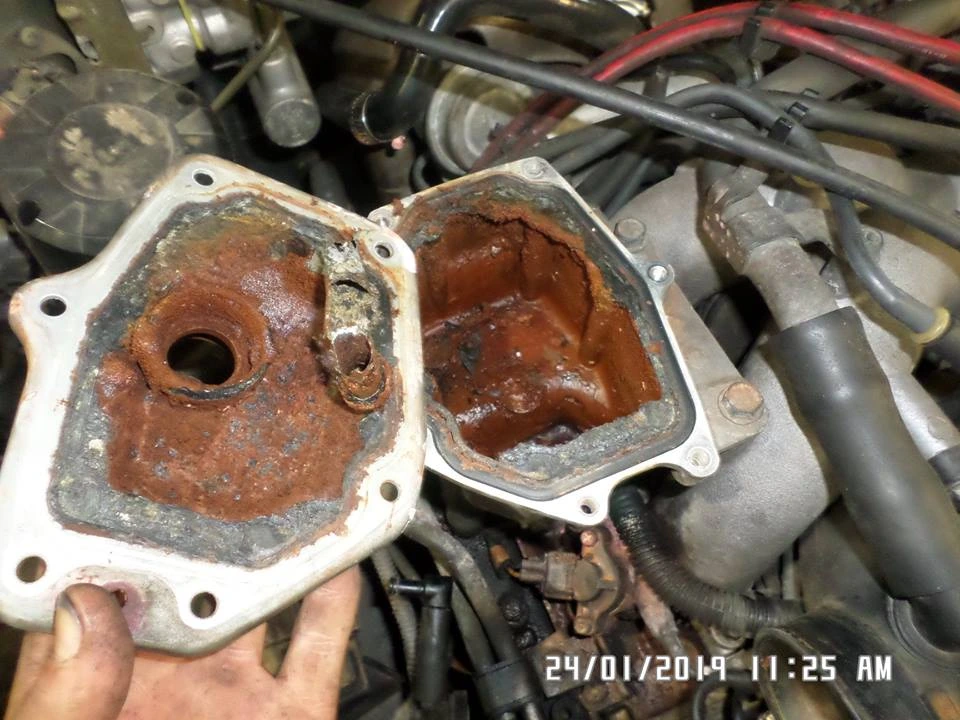 A heavily rusted coolant tank with its top off