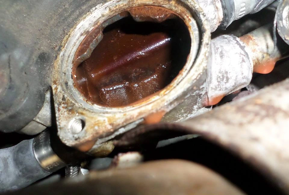Inside the water pump housing before the clean, coated in rust