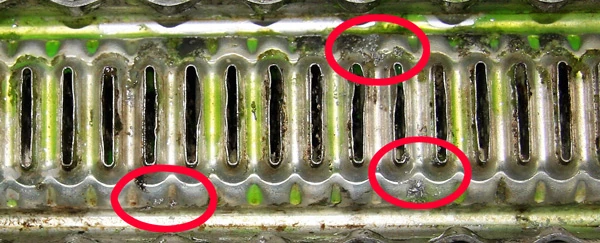 A radiator with its top tank removed after using 243: the flutes clear, with a few particles still dissolving, circled in red