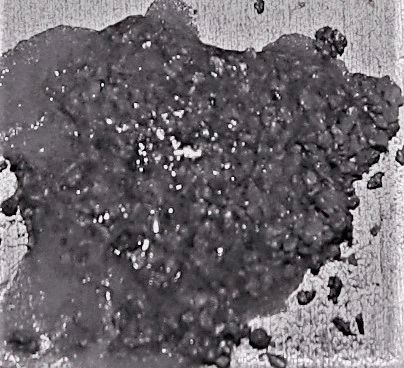 A dense, solid cluster of 243 particles bound together by hardened resin