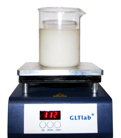 A beaker of milky 600 coolant on the hotplate reading 112°C