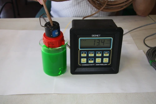 The meter reading 13.4 mS/cm in green corrosion inhibitor and water