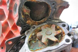 A water pump housing and impeller eaten away by galvanic corrosion