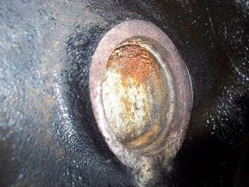 A rusted welch plug in the back of an engine block